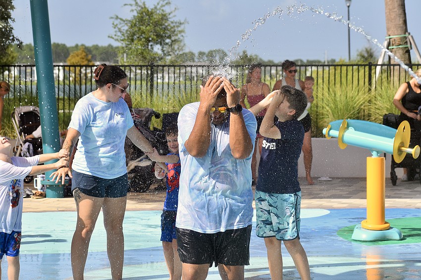 ABA therapist Marc Moyer gets sprayed with water.