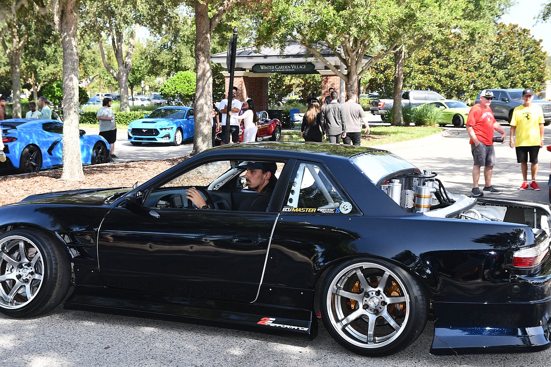 A driver is seen driving his car for the Cars and Coffee show.