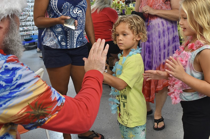 Surfer Santa meets Noah Adams, 4, and his sister Amelia Adams, 6.
