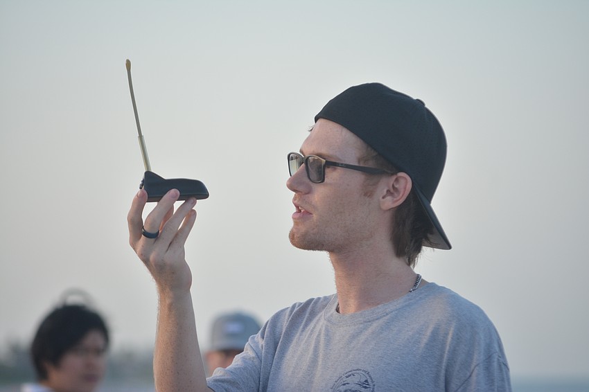 Volunteer Caleb Jameson shows turtle trackers that are used for further research.