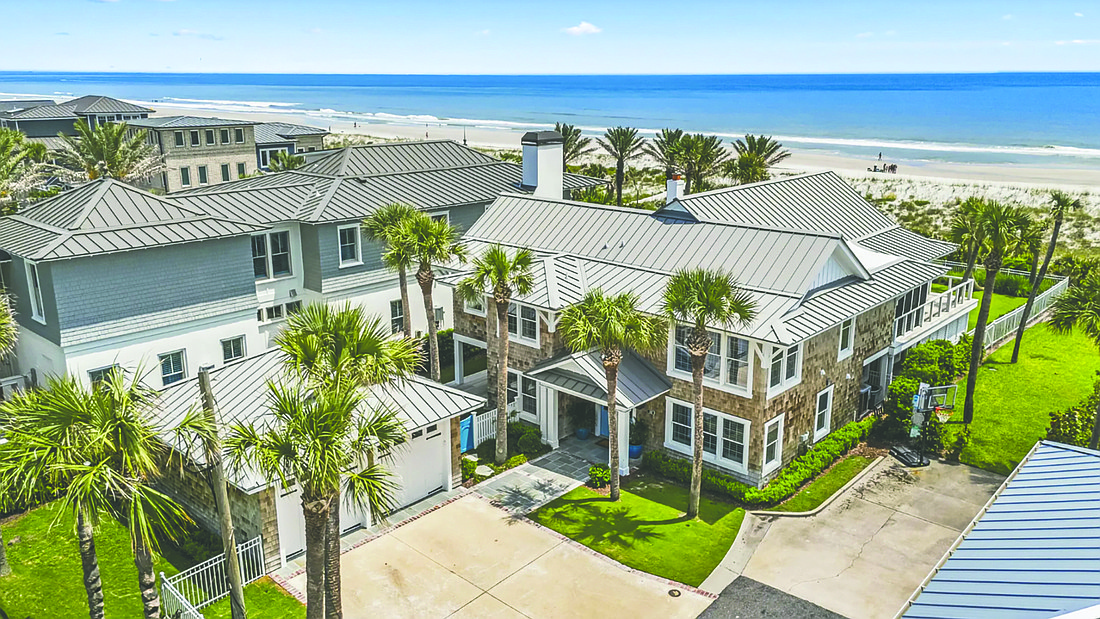 Oceanfront two-story home features five bedrooms, five full bathrooms, elevator, porches, balcony, patio and detached garage.