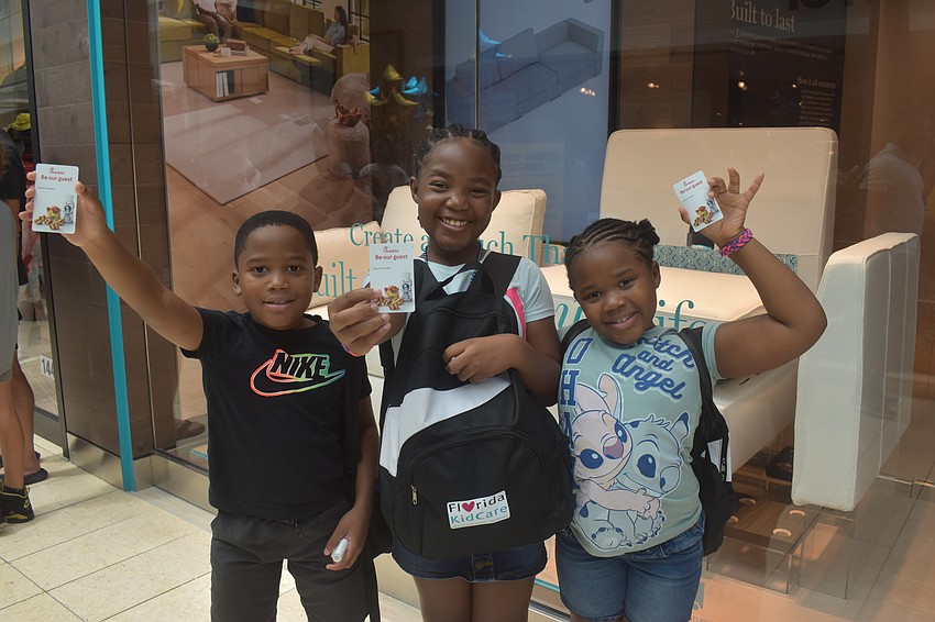 Noah, Abigail and Hannah Merone are eager to get a free kids meal at Chick-fil-A with their gift cards from the event.
