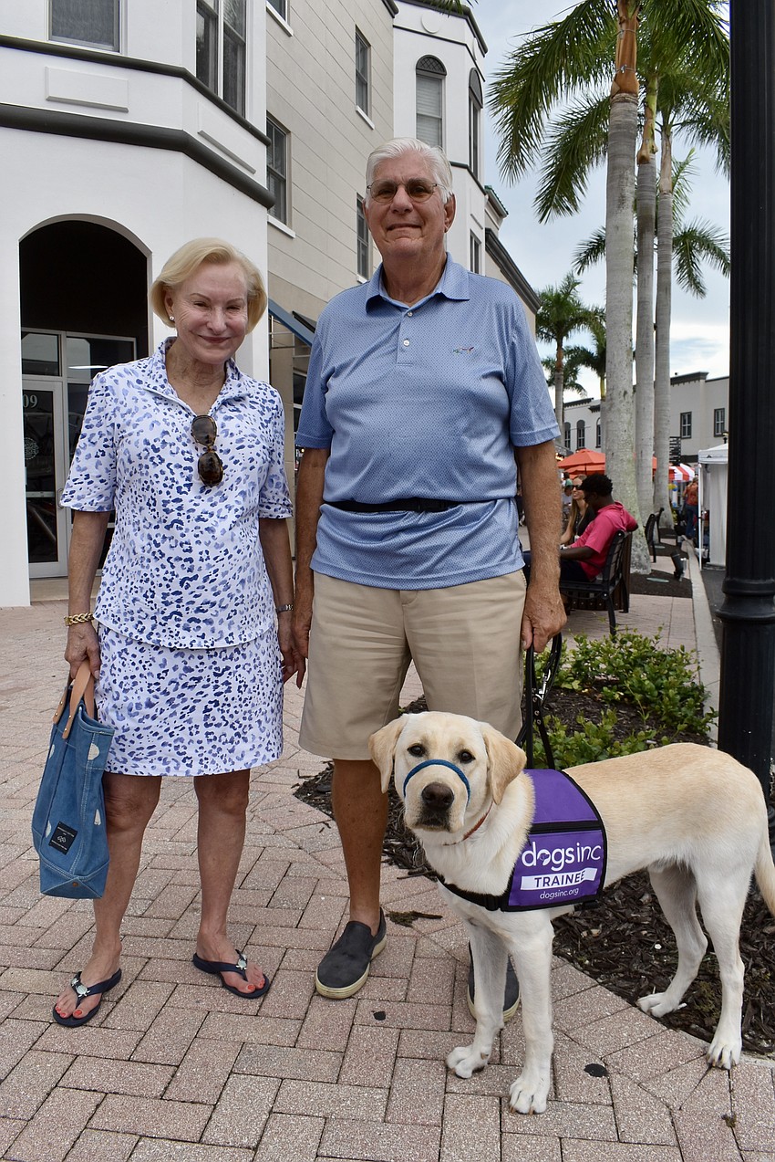 Mary and Bob Roby and Leader stroll Main Street after dinner at the Twisted Pit. Leader is the third puppy they've raised for Dogs Inc.