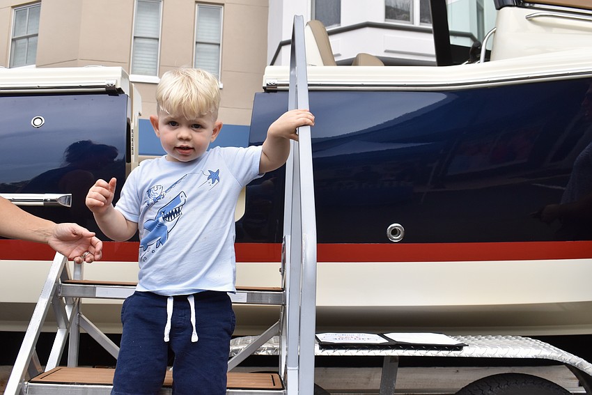 Bennett McComak, 2, isn't old enough to drive the Chris Craft Catalina 24 that the Viage Group parked at Music on Main, but he loves going up and down the stairs.