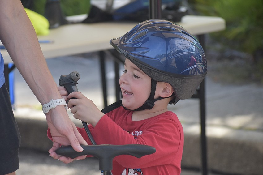 Kevin McGuckin, 3, enjoys working an air pump with his mother Kellie McGuckin.