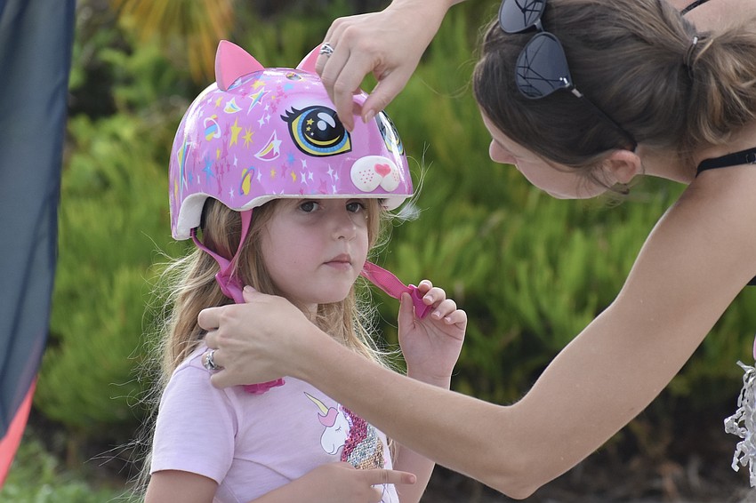 Eloise Windsor, 5, receives a helmet from her mother Christine Windsor.