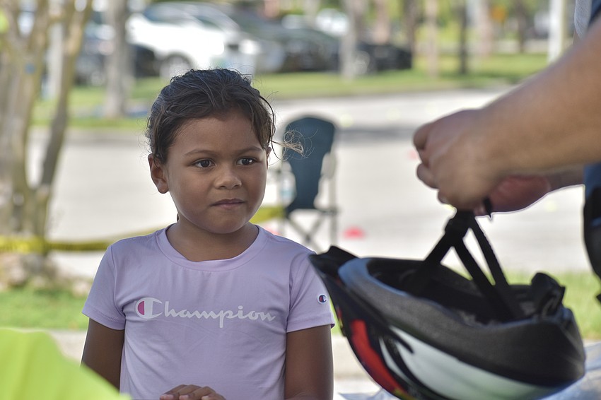 Maria Caro, 6, prepares to receive a helmet from Officer Matt Grochowski.
