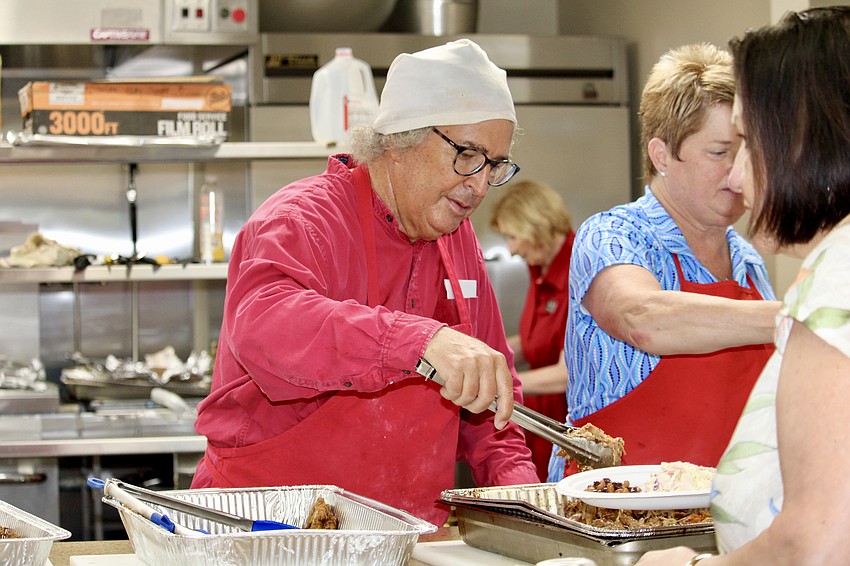Chef Fred Lugano dishes up pulled pork at Christ Church of Longboat Key's Aug. 3 fundraiser to support those recovering from severe flooding in Texas.