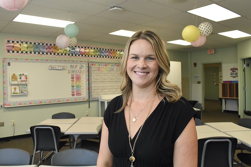 Casey Sullivan, a third grade English language arts and social studies teacher, stands inside the classroom she decorated.
