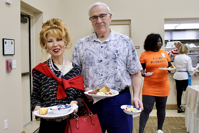 Grace Masefield and Bill McClure make a plate at the buffet fundraiser for Texas flooding relief.