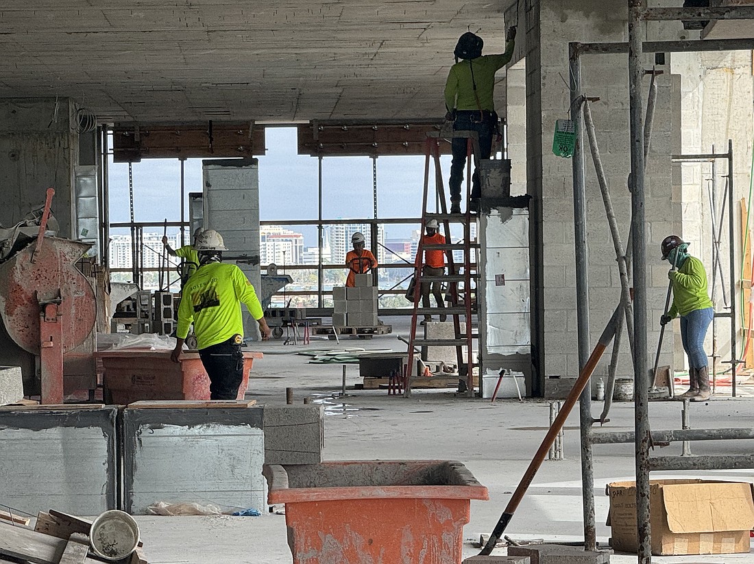 Construction employees work at a job site on Lido Key in Sarasota.
