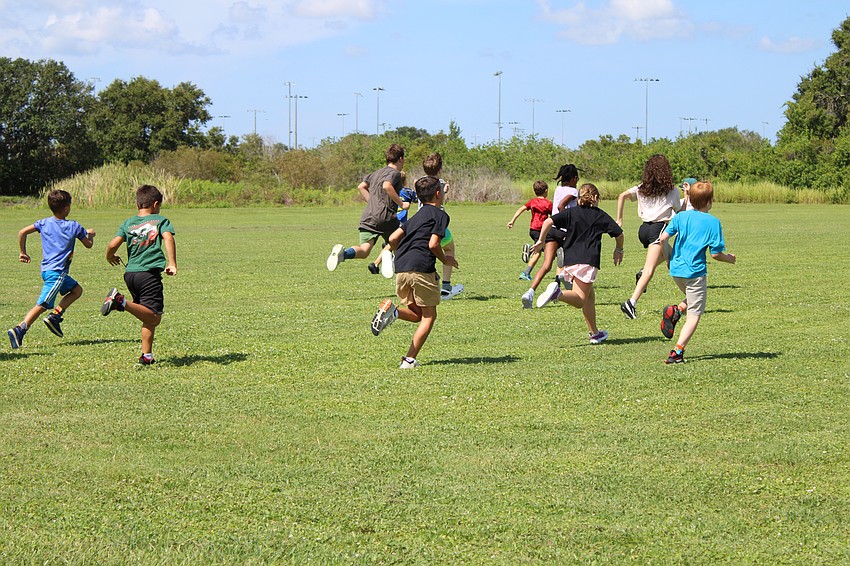 The triathlon trainees run as fast as they can to beat camp counselor Aiden Thede.