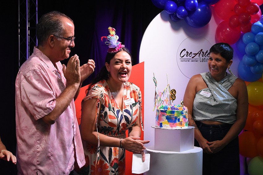 Board members Marc Masferrer, Co-founder and Producing Artistic Director Carolina Franco, and board member Amanda Rico celebrate as the candle is blown out.