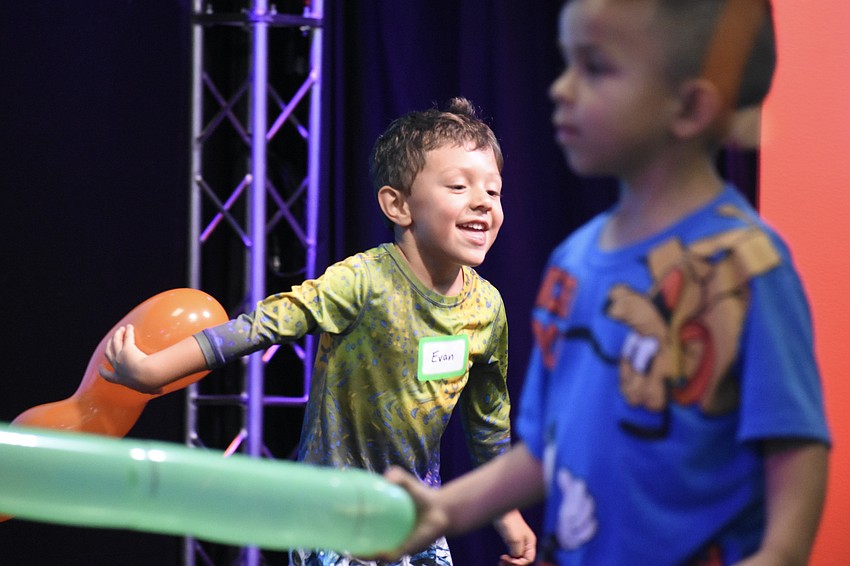 Evan Castano, 4, and Daniel Mendez, 4 run across the stage with balloons.