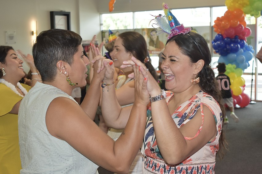 Board member Amanda Rico and Carolina Franco finish dancing with attendees.