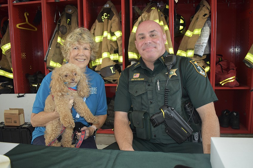 Linda Poulin of Humane Society of Sarasota County holds Teddy, with Deputy Brian Keane of the Sarasota County Sheriff's Office.