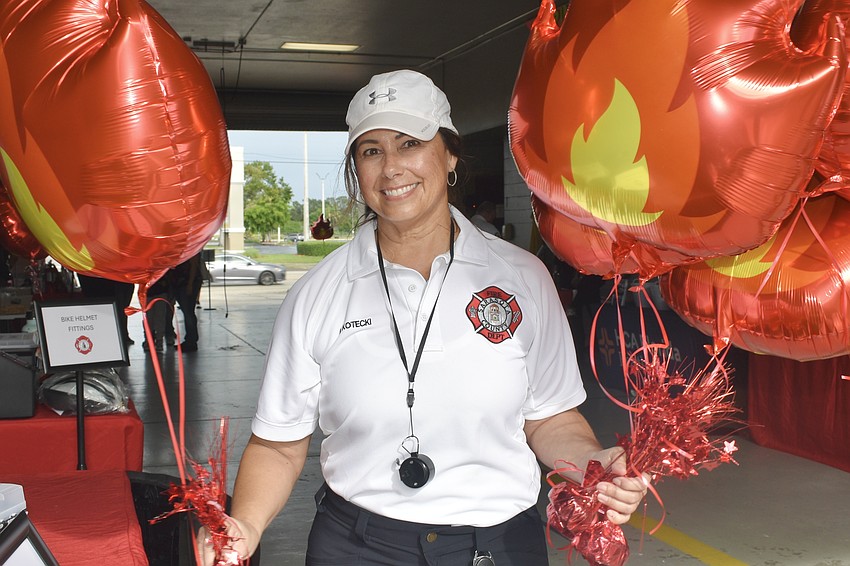 Brenda Kotecki, a member of the fire department administration, sets out balloons.
