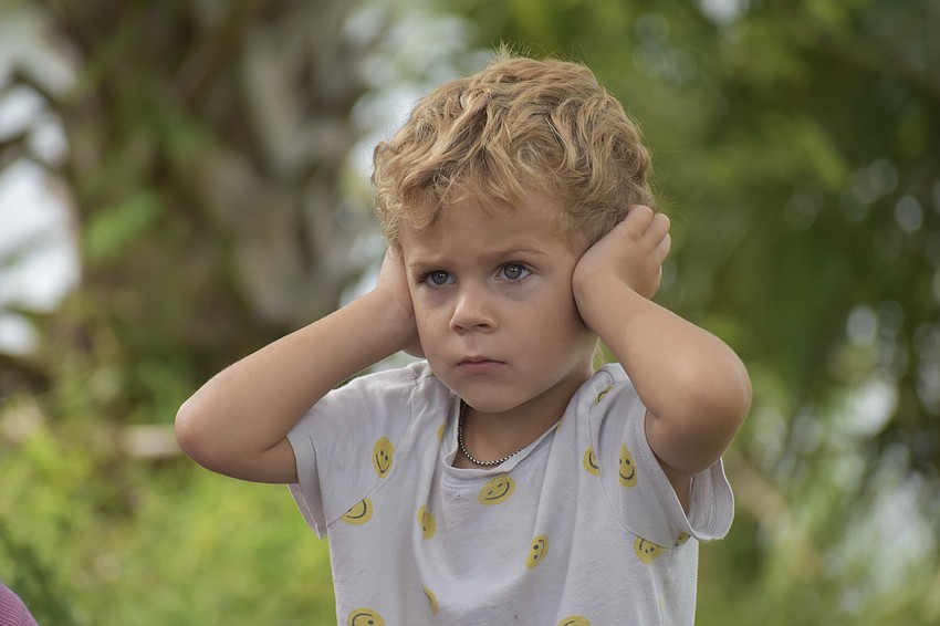 Rhett Hochstetler, 3, covers his ears as the helicopter lands.