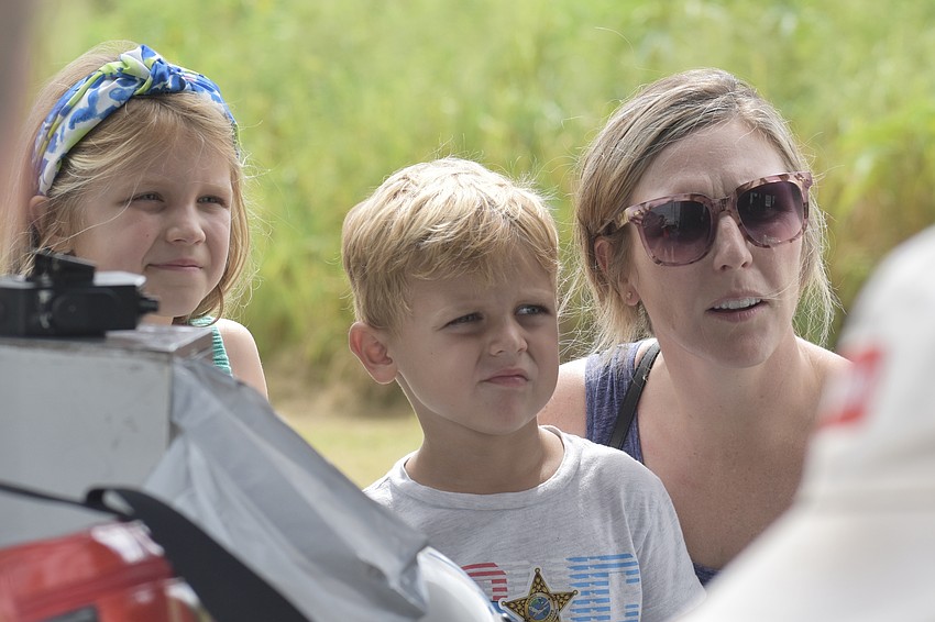 Valerie Altier, 6, her brother McClain Altier, 5, and their mother Kyle Altier look inside the helicopter.