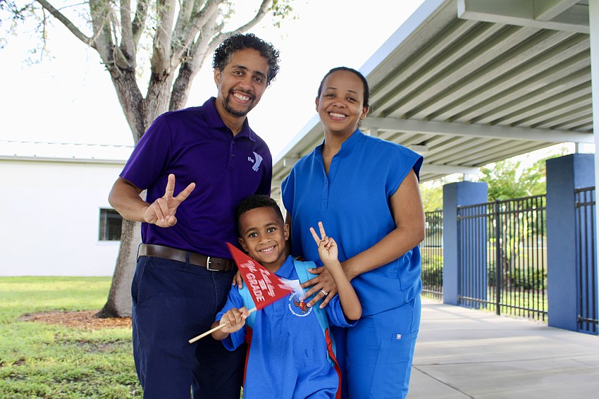Xavier Lora waves a flag celebrating his first day of first grade, which also will celebrate his last day in the grade, while heading off to Alta Vista Elementary School with parents José Lora and Beatriz Ryan-Lora.