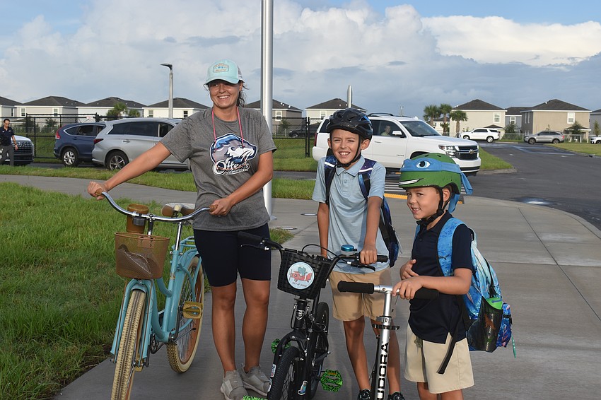 Biljana Haskic and students Damir and Zlatan Haskic ride bikes and a scooter to Lake Manatee for the for first day of school. Damir is starting fifth grade and Zlatan will begin as a second grader.