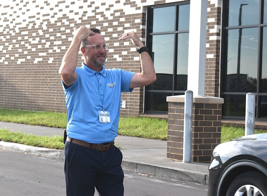 Principal Todd Richardson directs the car line in front of Lake Manatee, urging parents to keep the line moving in an efficient manner to start the school day as soon as possible.
