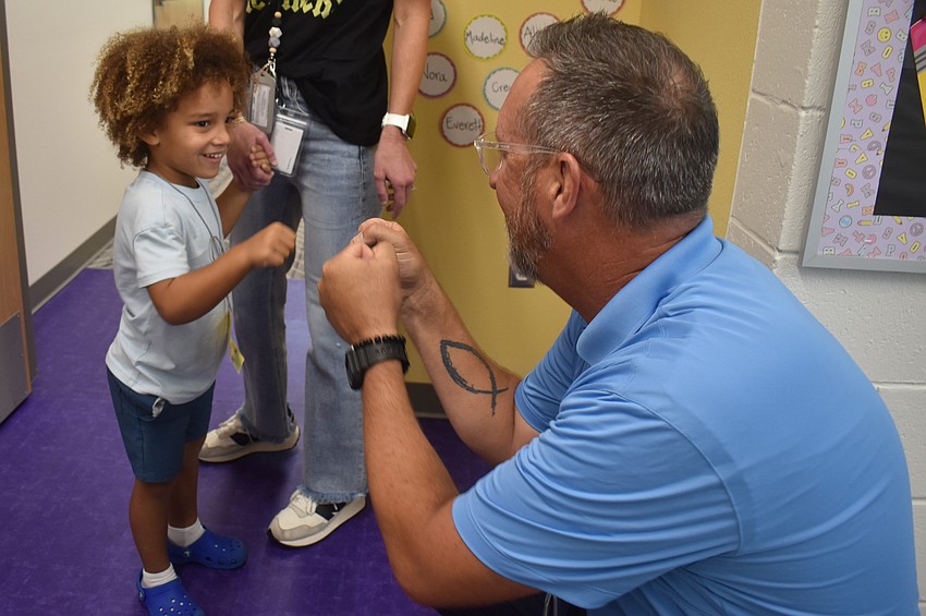 Pre-K student Crew Prime gets a fist bump from principal Todd Richardson. Prime's mother Jessie Bock teaches kindergarten at the school.