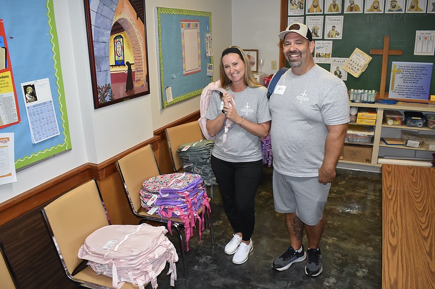 Volunteers Melissa Kubisiak and her husband Jason Kubisiak distributed backpacks to students.