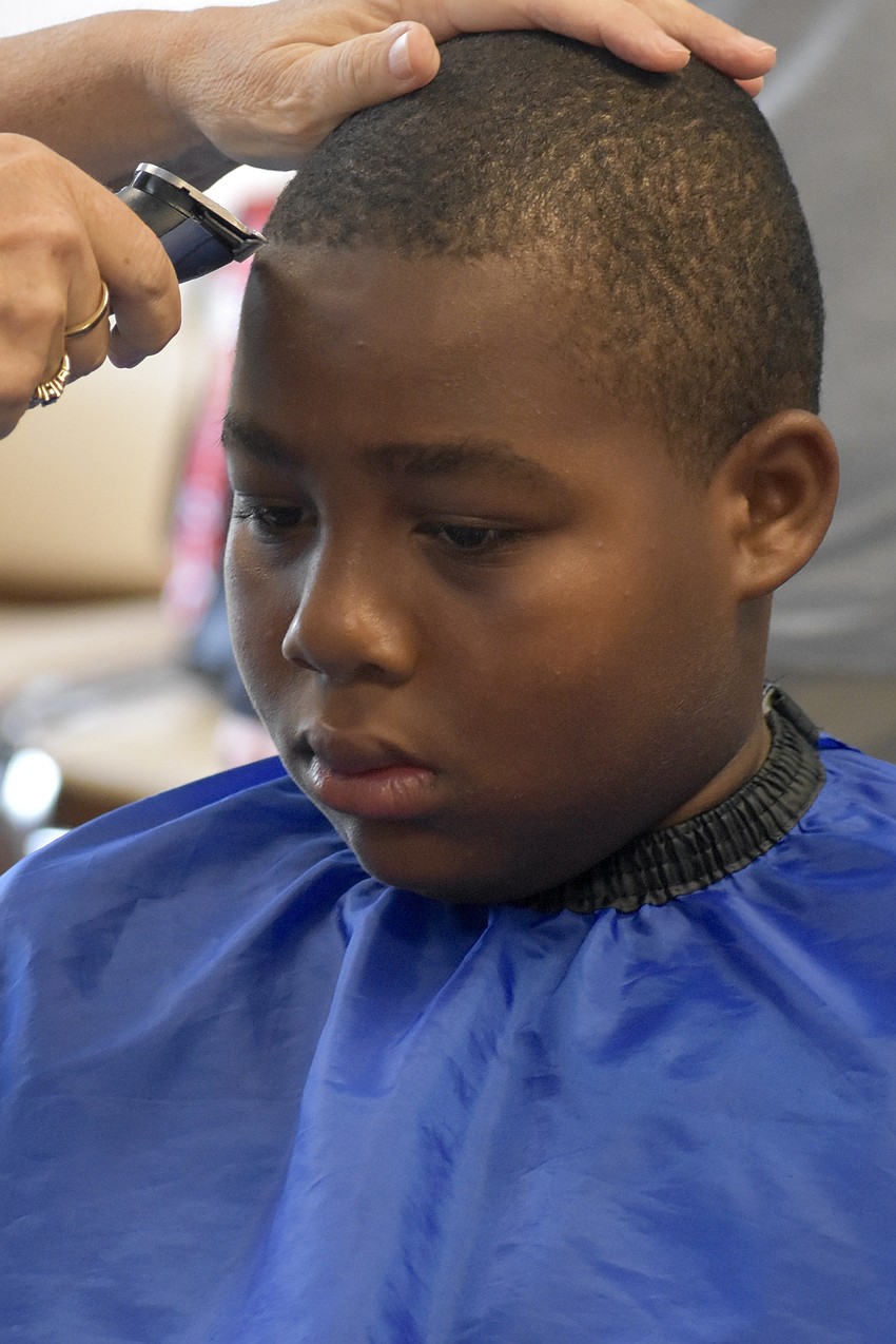 Ny'Davian Thomas, 9, receives a haircut.