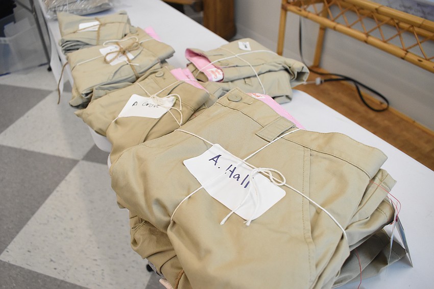 Clothes are set out on the table for students.