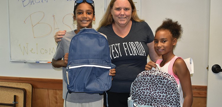 Andre Evans, 11, his mother Heather Abling, and cousin Nyomii Knight, 9, left with backpacks for the school year.