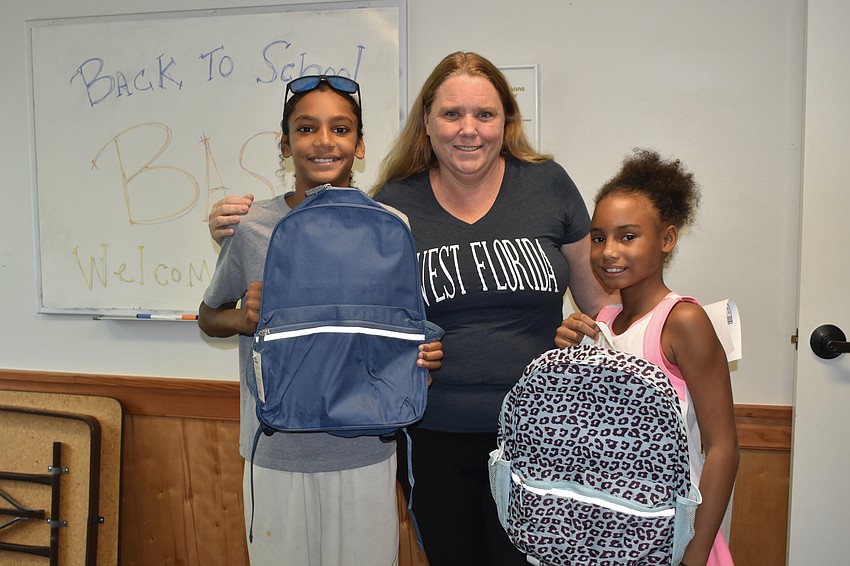 Andre Evans, 11, his mother Heather Abling, and cousin Nyomii Knight, 9, left with backpacks for the school year.