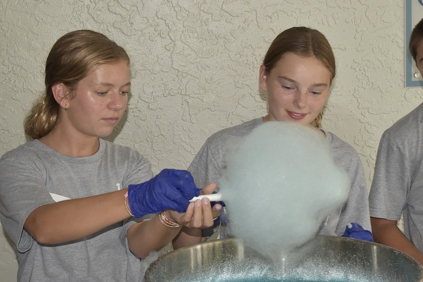 Lucy Mangum, 13, and Carolina Piazza, 13, make cotton candy.