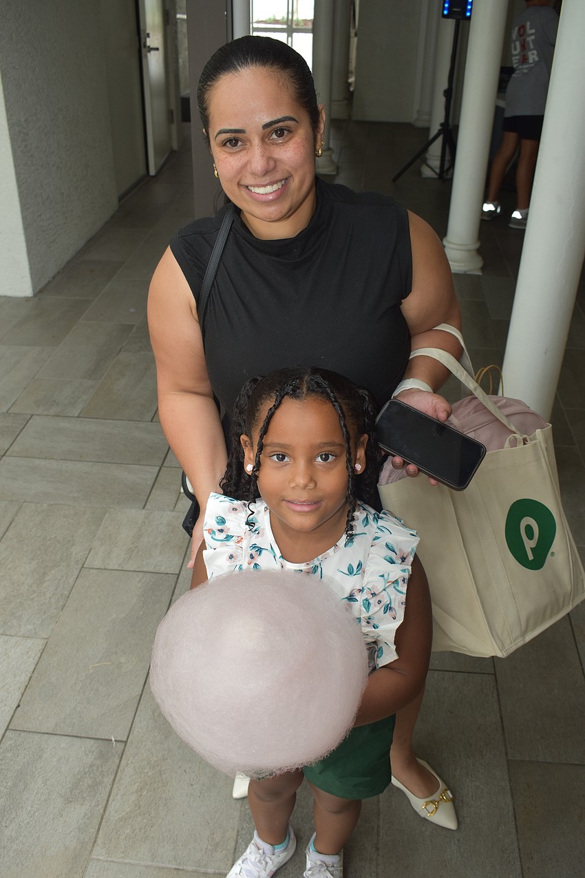 Yasmin Sabrina, who is entering kindergarten, enjoys cotton candy with Rosa Soares.