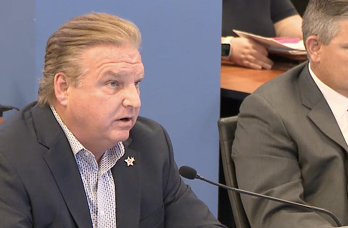 Sarasota County Tax Collector Mike Moran (left) talks budget with county commissioners as County Administrator Jonathan Lewis looks on.