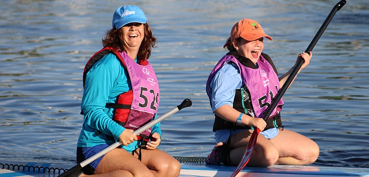 St. Lucie County's Sara Rosenzweig and Volusia County's Copper Reynolds share a moment of excitement as they complete their 100 meter race at the Special Olympics Florida 2025 State Stand Up Paddle Competititon on Aug. 16.