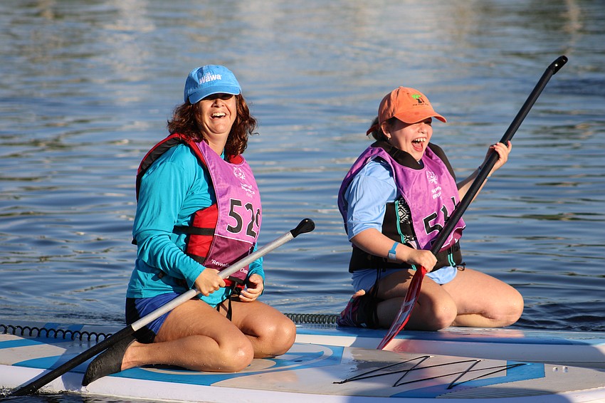 St. Lucie County's Sara Rosenzweig and Volusia County's Copper Reynolds share a moment of excitement as they complete their 100 meter race at the Special Olympics Florida 2025 State Stand Up Paddle Competititon on Aug. 16.