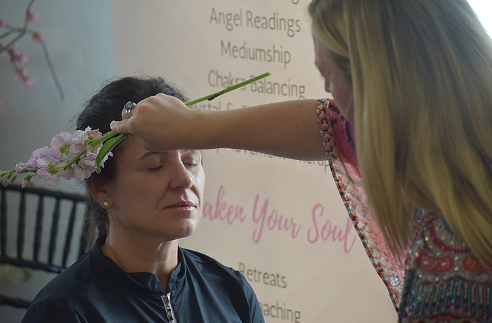 Ana Salmon receives a demonstration from Elyse Falzone, an intuitive energy healer and spiritual mentor.