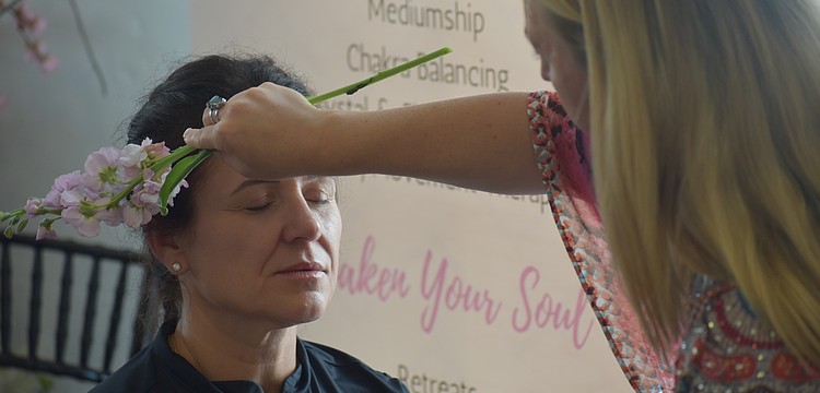 Ana Salmon receives a demonstration from Elyse Falzone, an intuitive energy healer and spiritual mentor.