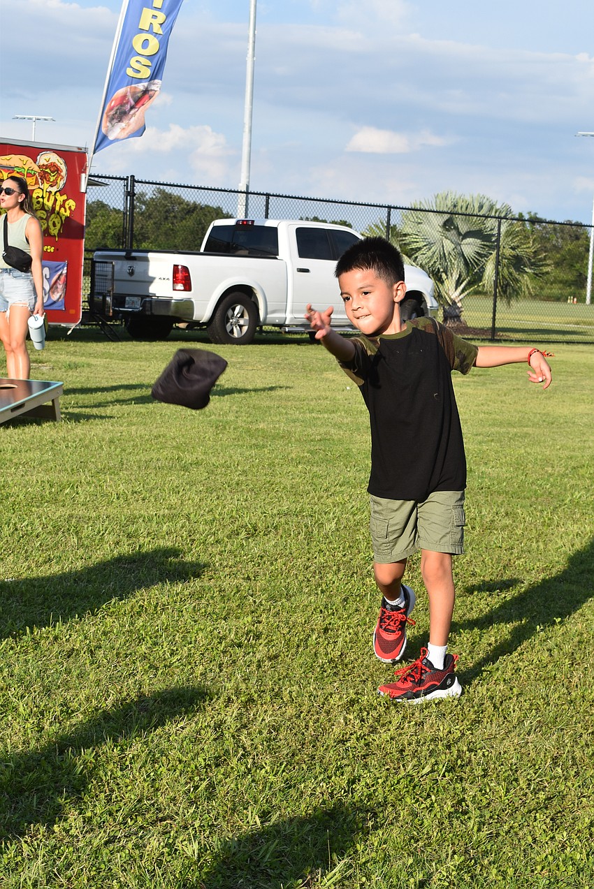 Bradenton's Leonardo Contreras, 6, plays cornhole.