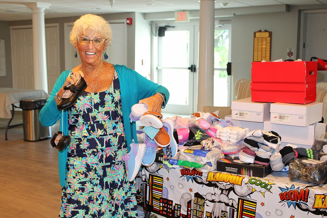 Connie DiMaggio, a member of Longboat Island Chapel, shows off some of the stylish shoes community members donated to its shoe drive-focused Gather and Give on Aug. 19 at the chapel.