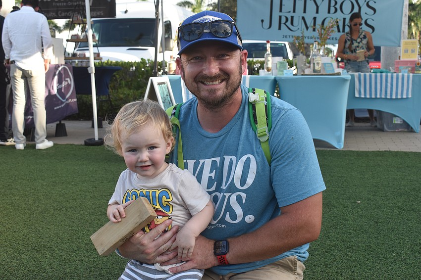 Lakewood Ranch's Tj Sayre and 1-year-old son Benjamin Sayre check out the oversized Jenga game on The Green.