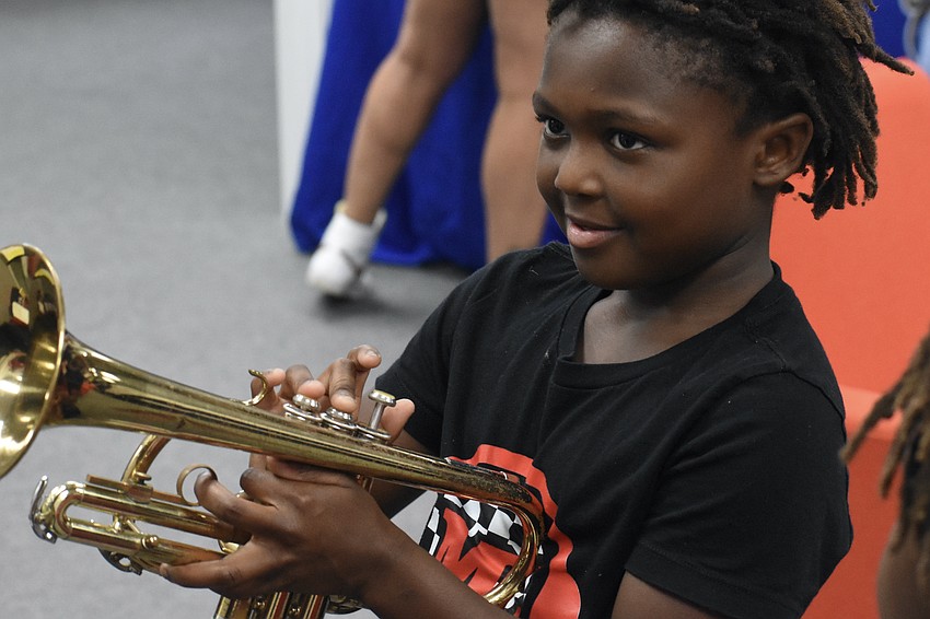 Rebekah Miller, 8, learns about how the trumpet works from David DeWitt.
