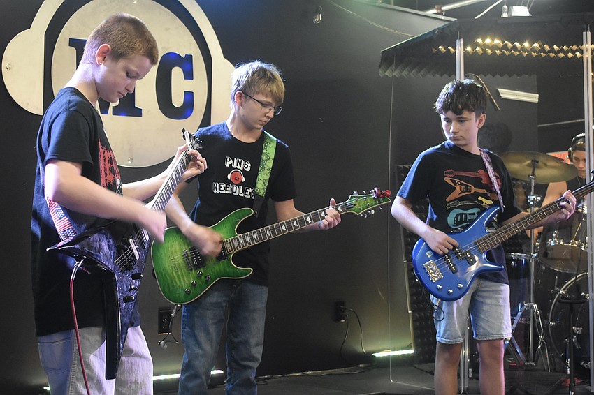 Pins and Needles members Liam Stevens, 14, Liam Geske, 15, and Christian Bathori, 13, perform on stage.