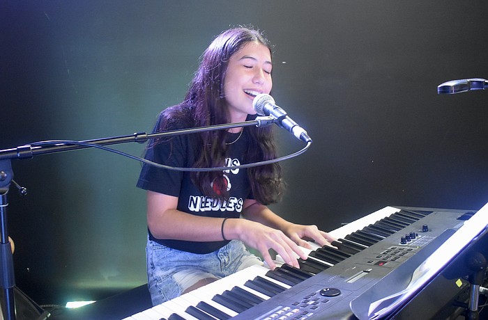 Nina Young, 13, of the band Pins and Needles, performs on stage.
