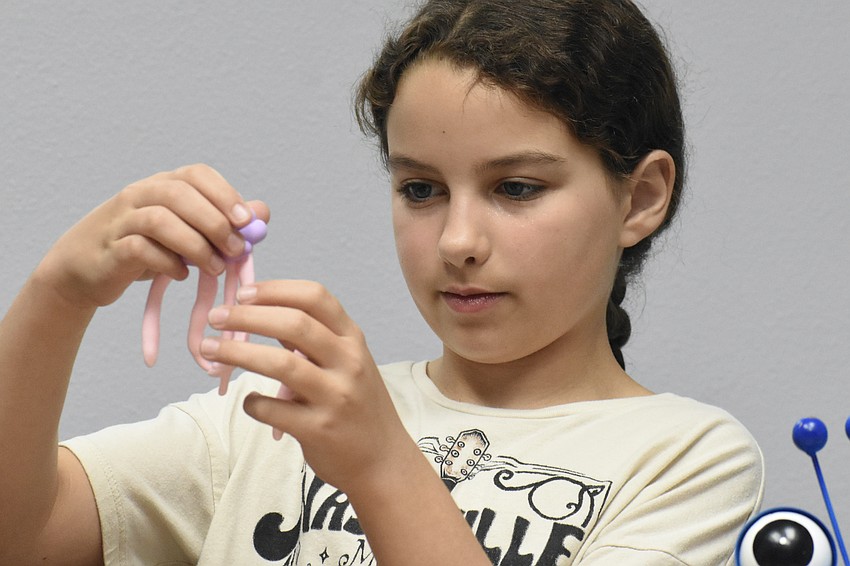 Olivia Roux, 10, makes a jellyfish at te table of Children's Art Classes.