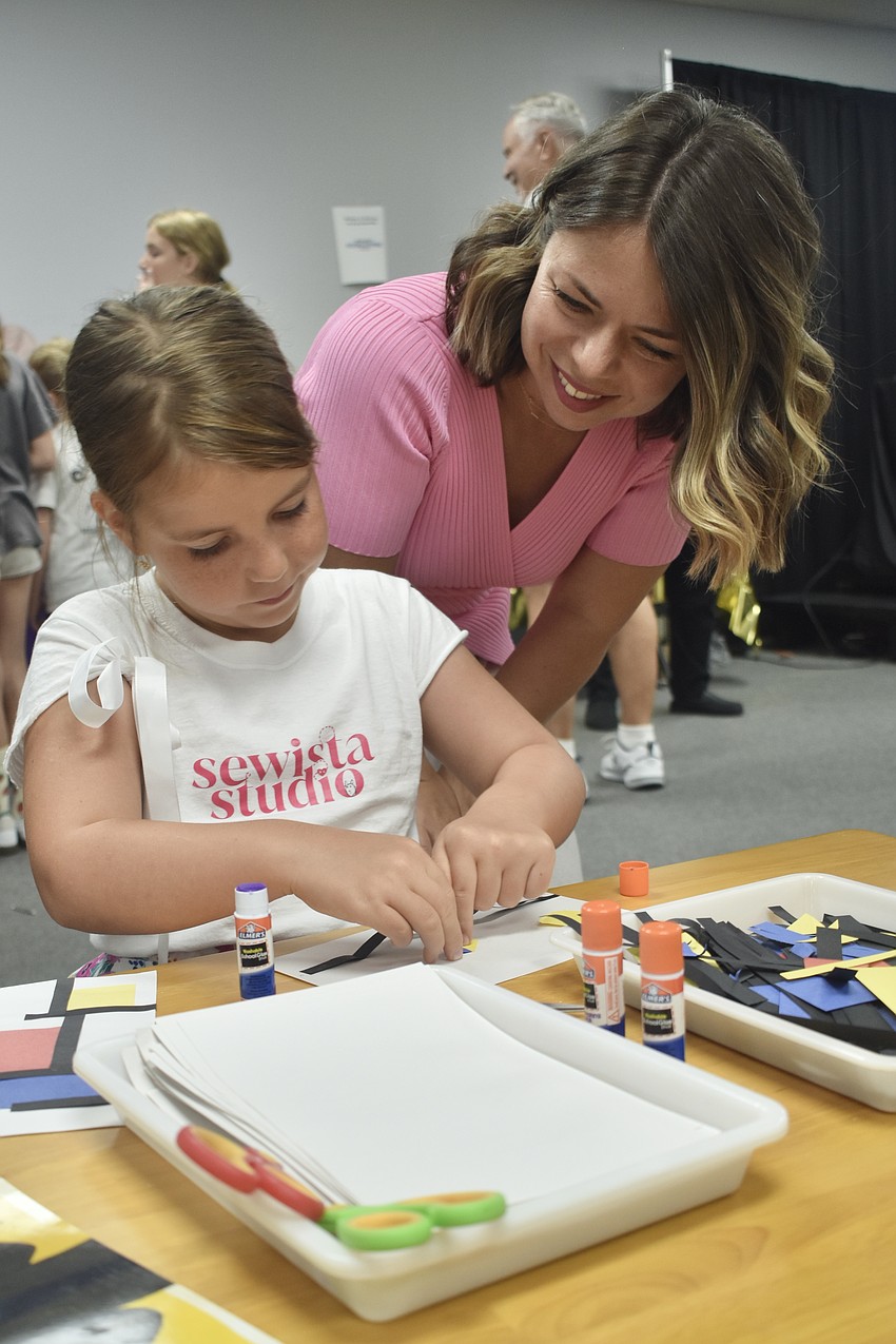 Mila Ostrovskiy, 8, assembles a collage of colors at the table by Theory of Play, alongside her mother Anna Ostrovskiy.