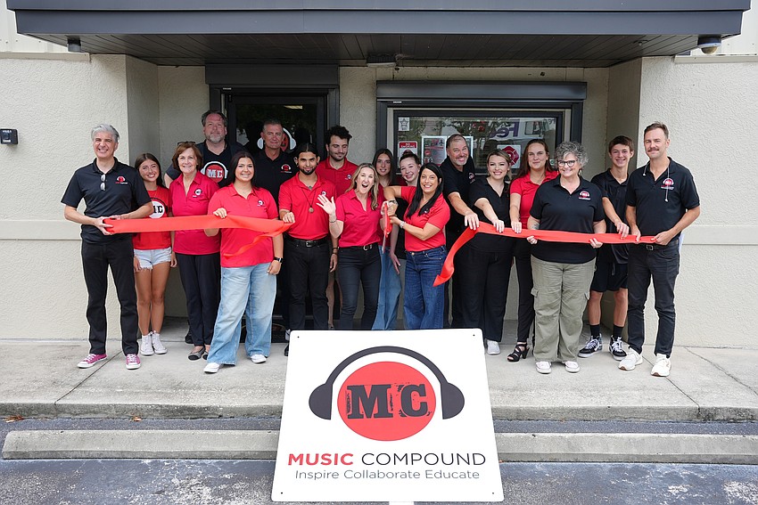 Music Compound staff hold a ribbon cutting for the current location.