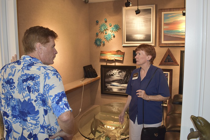 Brian Hallam of Wyland Galleries talks with Nancy Taussig.