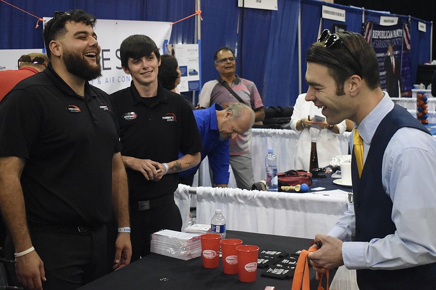 Karem Ismail and Jason Kirby of Tommy's Express Car Wash talk with event attendee Philip Schildknecht.